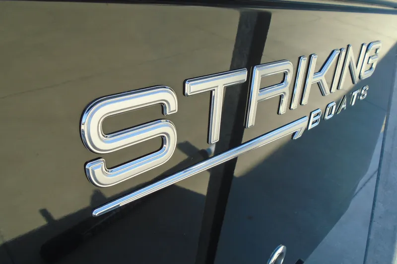 Slide: The Image of Close-up of STRIKING BOATS 26XB logo on a sleek surface, 2027 model. - 19