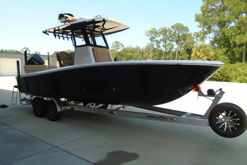 Slide: The Image of 2027 STRIKING BOATS 26XB on trailer, sleek design, parked outdoors. - 1