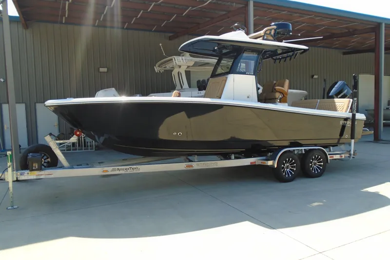 The Image of 2027 STRIKING BOATS 26XB on trailer, sleek design, parked in covered area. - 0