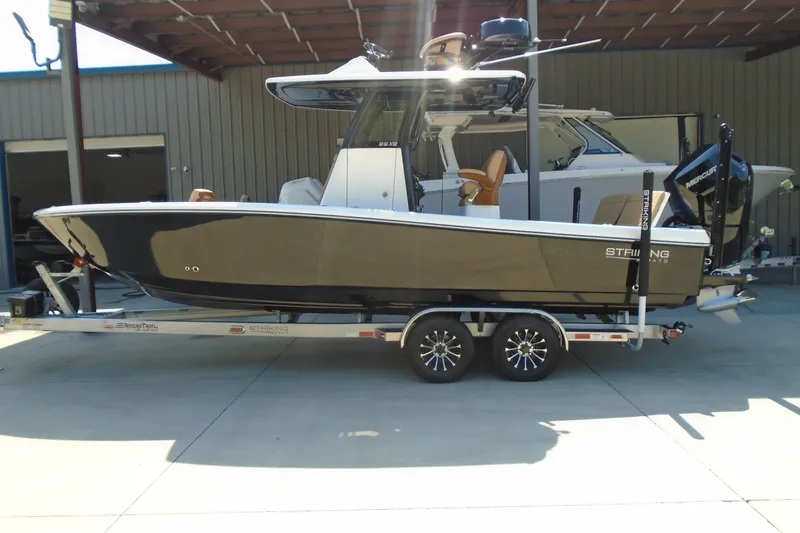 Slide: The Image of 2027 STRIKING BOATS 26XB on trailer, sleek design, parked outdoors. - 22