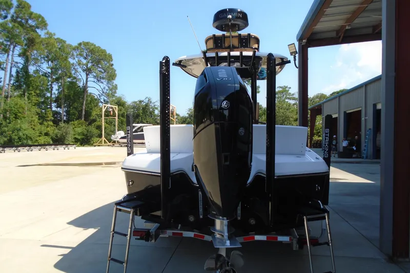 Slide: The Image of 2027 STRIKING BOATS 26XB with powerful outboard motor, parked outdoors. - 13