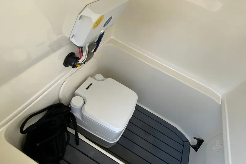 Slide: The Image of 2025 Pathfinder 2600 TRS boat interior with portable toilet and storage compartment. - 38