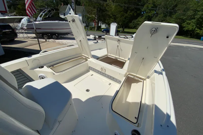 Slide: The Image of 2025 Pathfinder 2600 TRS boat with open storage compartments and seating, docked outdoors. - 28