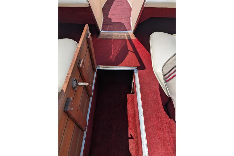 Slide: The Image of Interior view of 1987 Sea Ray Sorrento 23 boat with red carpet and storage compartment. - 5
