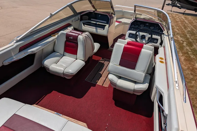 Slide: The Image of 1987 Sea Ray Sorrento 23 boat interior with red and white seating, dashboard, and steering wheel. - 1