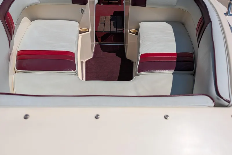 Slide: The Image of 1987 Sea Ray Sorrento 23 boat interior with white and red cushioned seating. - 8