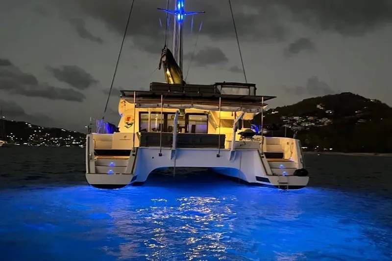 Slide: The Image of 2021 Fountaine Pajot SABA 50 catamaran illuminated at night with blue underwater lights. - 20