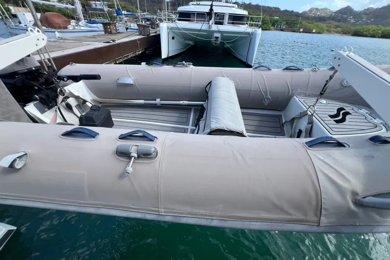 Slide: The Image of Inflatable dinghy docked near a 2021 Fountaine Pajot SABA 50 catamaran in a marina. - 112
