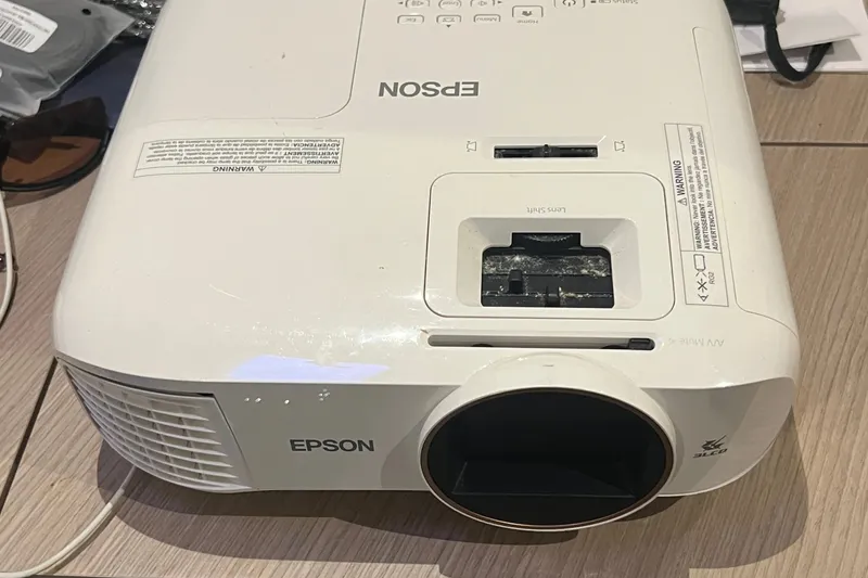 Slide: The Image of Epson projector on wooden surface, displaying lens and control panel. - 121
