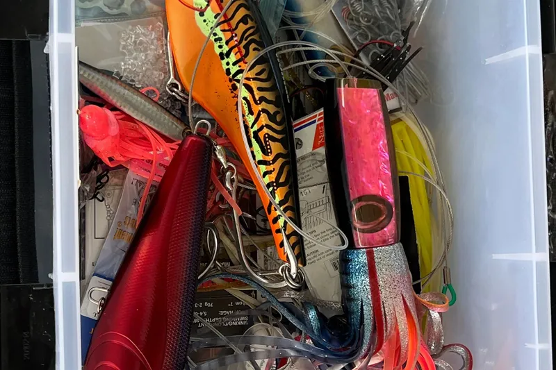 Slide: The Image of A collection of colorful fishing lures and tackle in a storage box. - 84