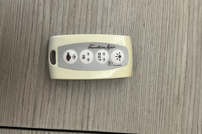 Slide: The Image of Remote control for Fountaine Pajot SABA 50 yacht, 2021 model, on wooden surface. - 100