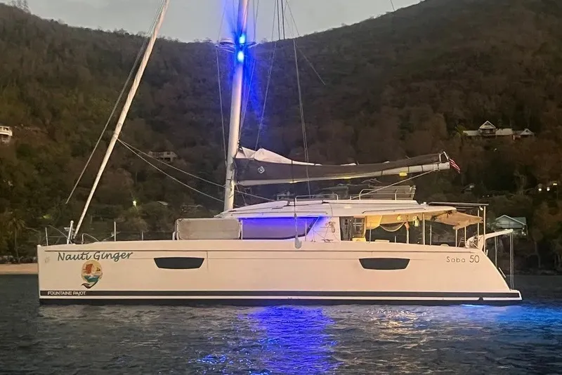 Slide: The Image of 2021 Fountaine Pajot SABA 50 catamaran illuminated at dusk on calm waters. - 129