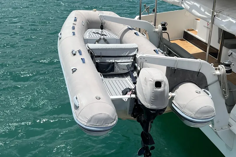Slide: The Image of Inflatable dinghy attached to 2021 Fountaine Pajot SABA 50 catamaran on turquoise water. - 122