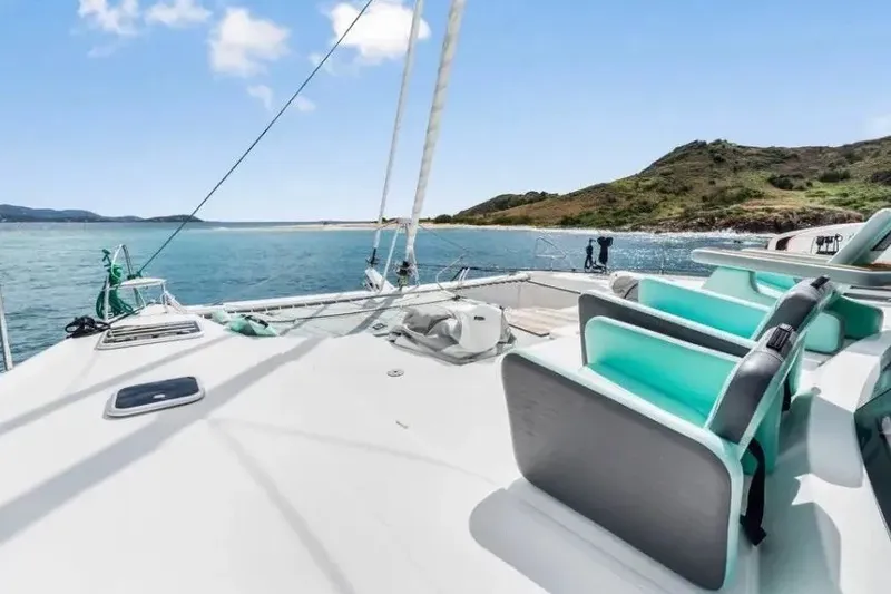 Slide: The Image of 2021 Fountaine Pajot SABA 50 catamaran on serene waters with scenic island backdrop. - 52