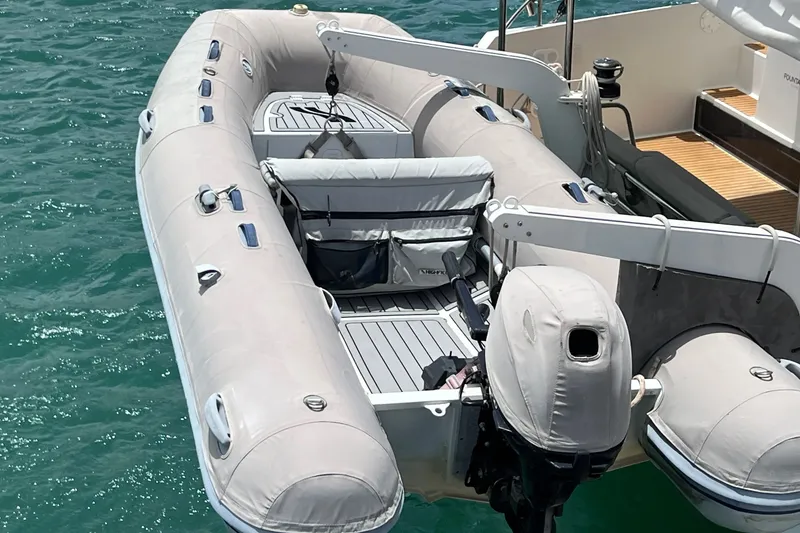 Slide: The Image of Inflatable dinghy attached to a 2021 Fountaine Pajot SABA 50 catamaran on turquoise water. - 18