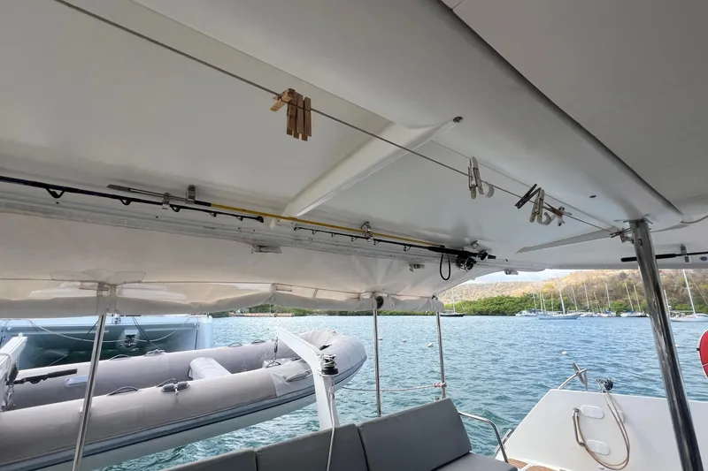 Slide: The Image of 2021 Fountaine Pajot SABA 50 catamaran deck with dinghy and scenic water view. - 76