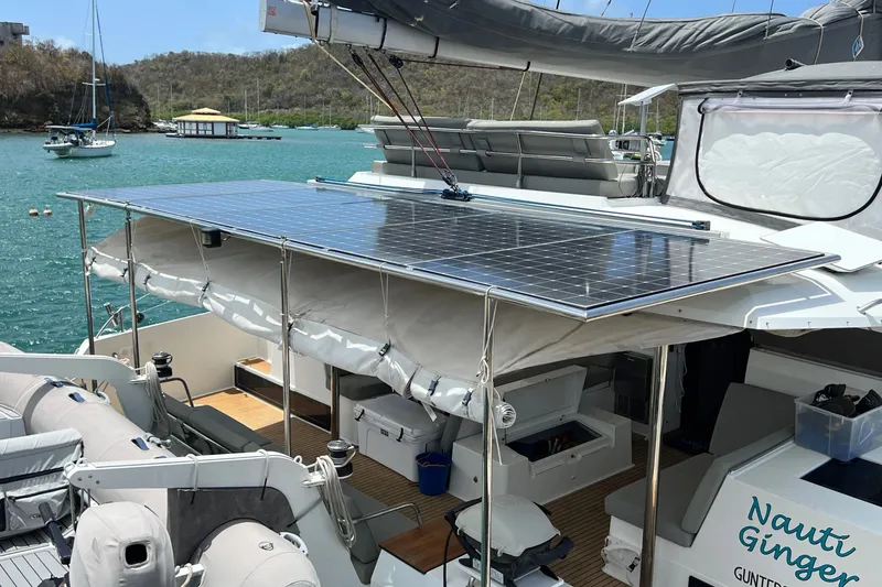 Slide: The Image of 2021 Fountaine Pajot SABA 50 catamaran with solar panels, docked in a scenic bay. - 63