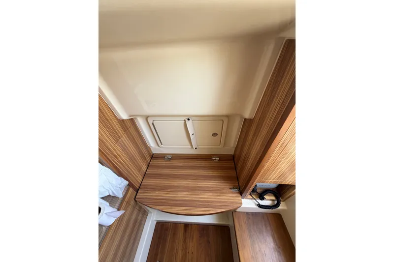 Slide: The Image of Interior view of 2017 Chris-Craft Catalina 34, featuring wood paneling and storage compartment. - 24