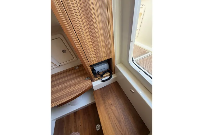 Slide: The Image of 2017 Chris-Craft Catalina 34 interior with wood cabinetry and storage compartment. - 26