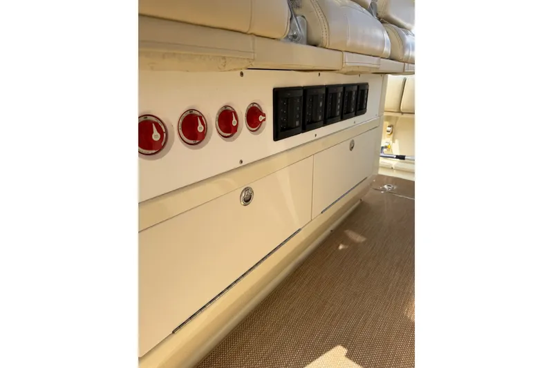 Slide: The Image of 2017 Chris-Craft Catalina 34 interior showing control panel and switches on beige upholstery. - 34