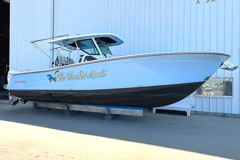 The Image of 2021 Blackfin 332 CC boat on display, light blue hull, docked indoors. - 0