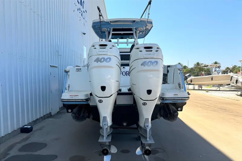 Slide: The Image of 2021 Blackfin 332 CC boat with twin 400 horsepower engines, docked outdoors. - 2