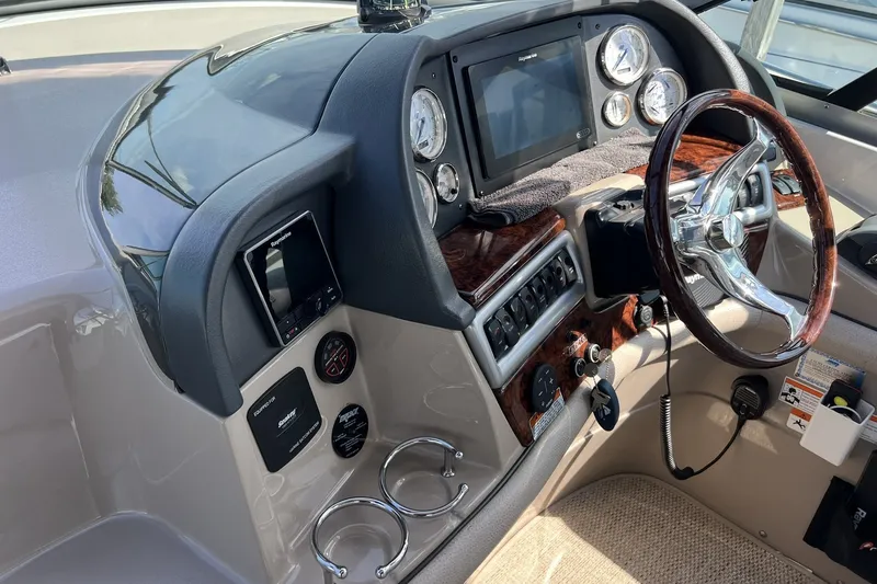 Slide: The Image of 2006 Four Winns 348 Vista boat dashboard with steering wheel and navigation controls. - 38