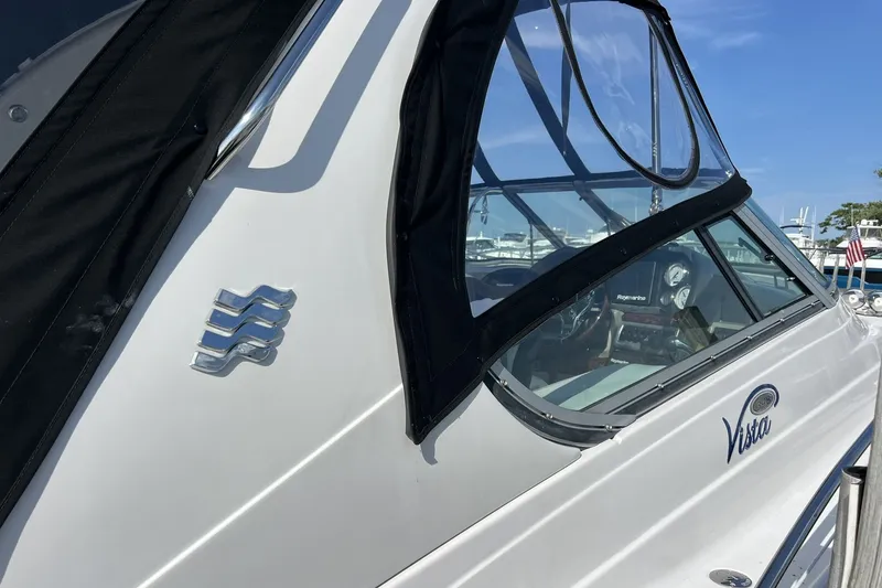 Slide: The Image of 2006 Four Winns 348 Vista boat with sleek design and clear windows at a marina. - 23