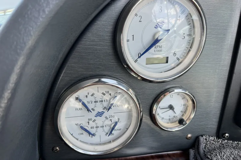 Slide: The Image of Dashboard gauges of a 2006 Four Winns 348 Vista boat, displaying RPM, fuel, and temperature. - 16