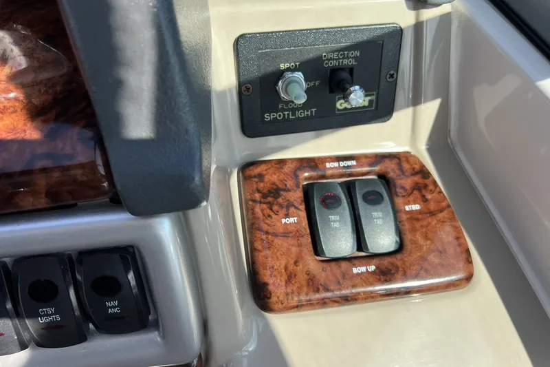 Slide: The Image of Control panel of a 2006 Four Winns 348 Vista boat with spotlight and trim tab switches. - 17