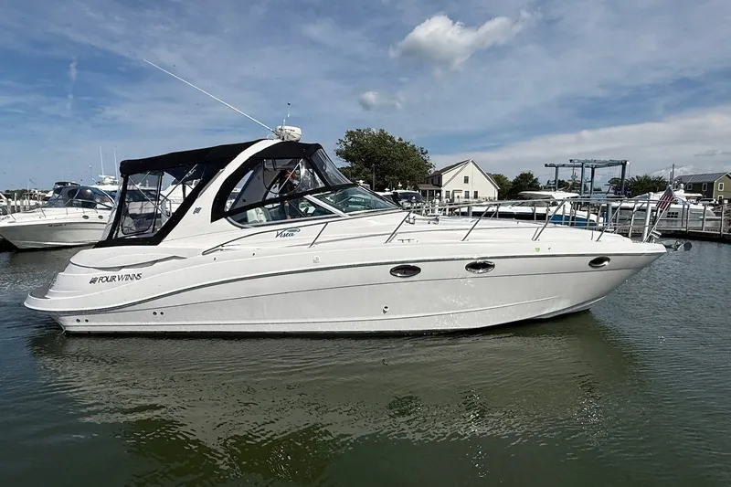 The Image of 2006 Four Winns 348 Vista boat docked in a marina under a clear sky. - 0