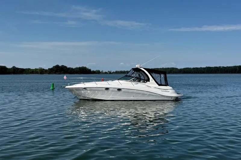 Slide: The Image of A white Four Winns 348 Vista motor yacht from 2006 floats on calm water. - 1