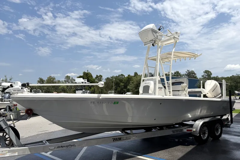 Slide: The Image of 2022 Pathfinder 2600 HPS boat on trailer under clear sky. - 1