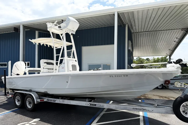 The Image of 2022 Pathfinder 2600 HPS boat on trailer, parked outside a blue building. - 0