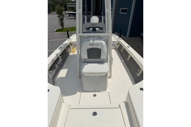 Slide: The Image of 2022 Pathfinder 2600 HPS boat interior with seating and console, docked outdoors. - 17