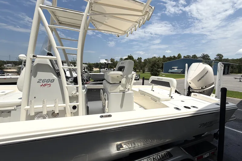 Slide: The Image of 2022 Pathfinder 2600 HPS boat with Mercury engine, parked outdoors under a clear sky. - 5