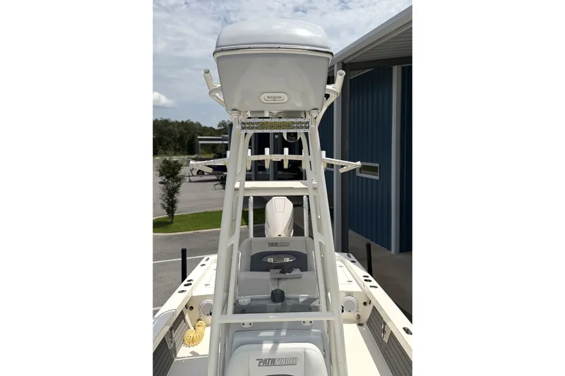 Slide: The Image of 2022 Pathfinder 2600 HPS boat with tower, parked near a blue building. - 16