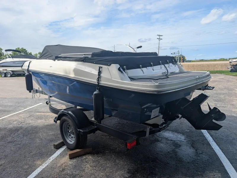 Slide: The Image of A 2023 Bayliner VR4 Bowrider on a trailer. The boat features a blue and white color scheme. - 2