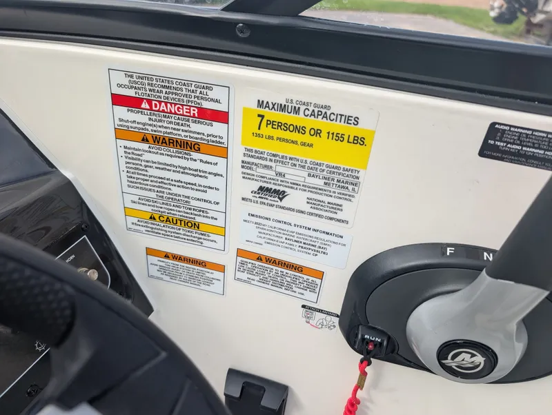 Slide: The Image of Close-up of a boat control area with warning labels and capacity information. - 12