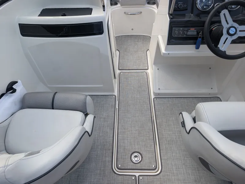 Slide: The Image of The image shows the cockpit of a 2023 Bayliner VR4 Bowrider with gray seats and carpeted flooring. - 11