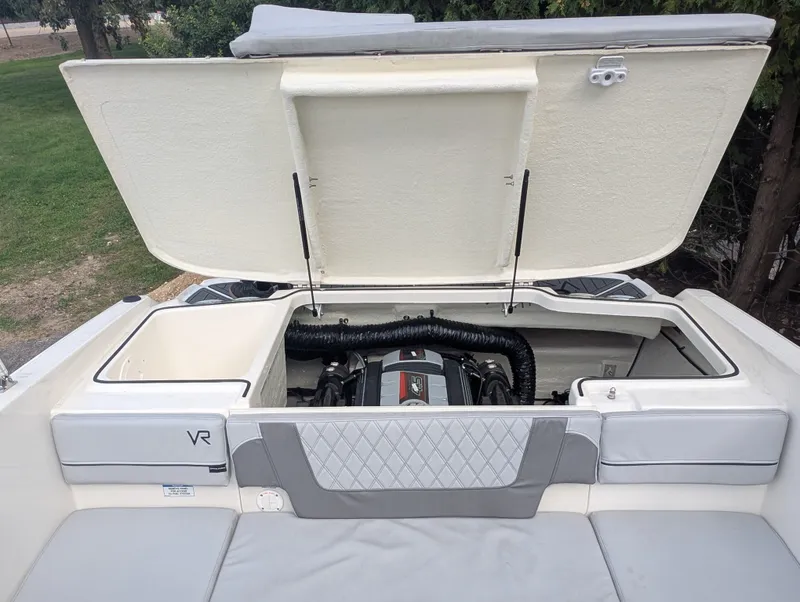 Slide: The Image of The 2023 Bayliner VR4 Bowrider features an open engine compartment with gray upholstery and sleek design. - 14