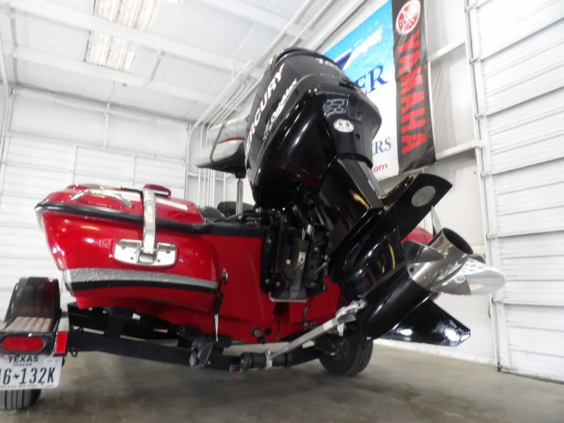 Slide: The Image of A red 2010 Nitro Z-7 boat with a large outboard motor in a garage. - 12