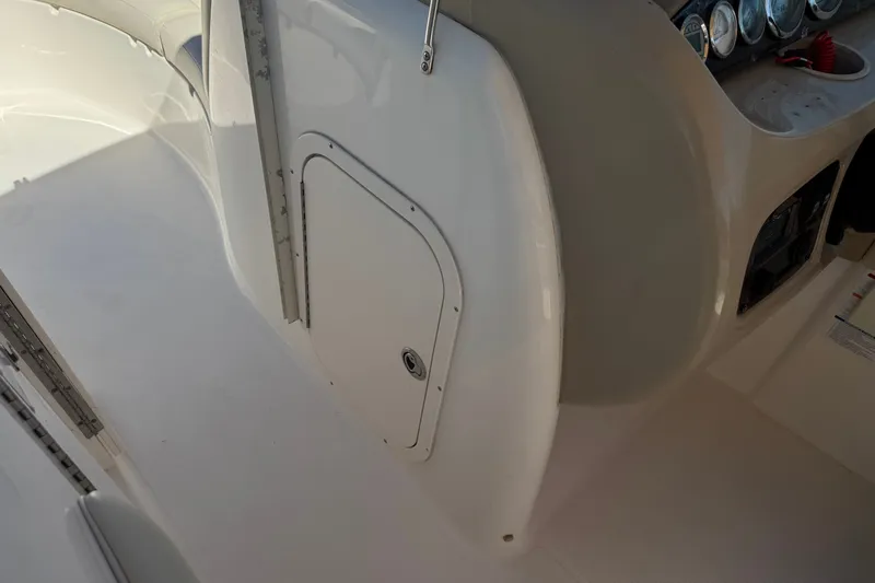 Slide: The Image of 2003 Chaparral Sunesta 263 boat interior with control panel and storage compartment. - 36