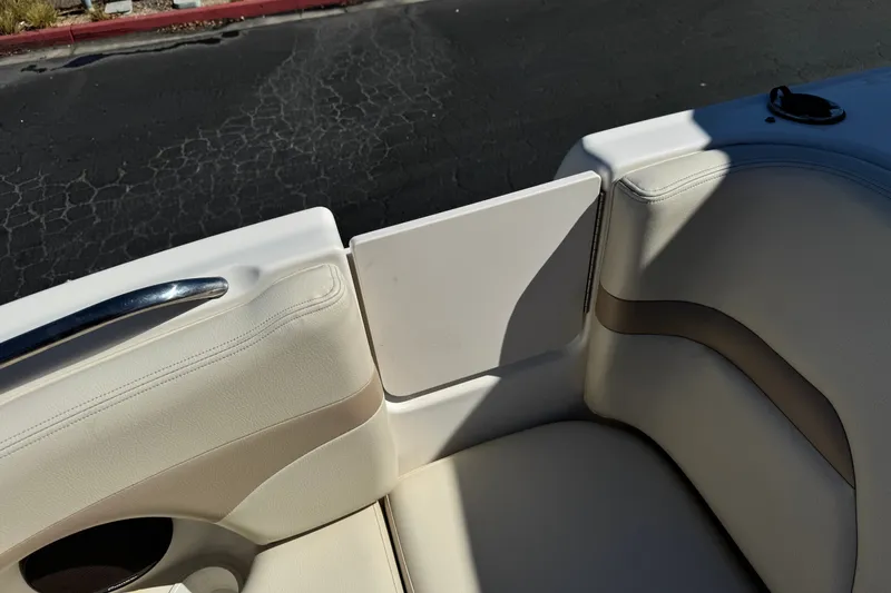 Slide: The Image of 2003 Chaparral Sunesta 263 boat interior with beige seating and cup holder. - 16