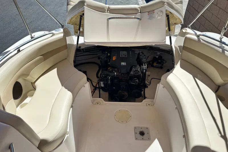 Slide: The Image of 2003 Chaparral Sunesta 263 boat engine compartment with seating and open engine cover. - 21