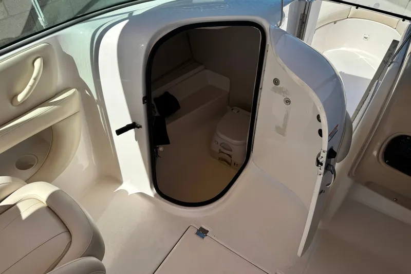 Slide: The Image of 2003 Chaparral Sunesta 263 boat interior with open cabin door and visible toilet. - 29