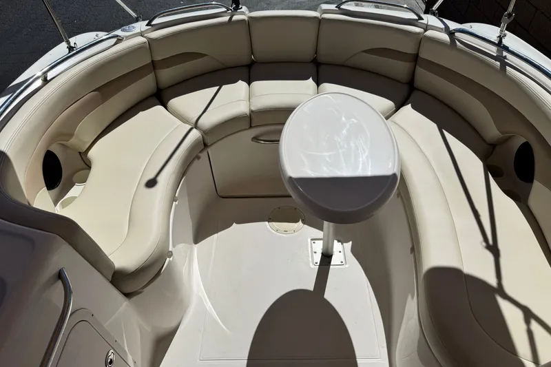 Slide: The Image of 2003 Chaparral Sunesta 263 boat interior with beige seating and a central table. - 20