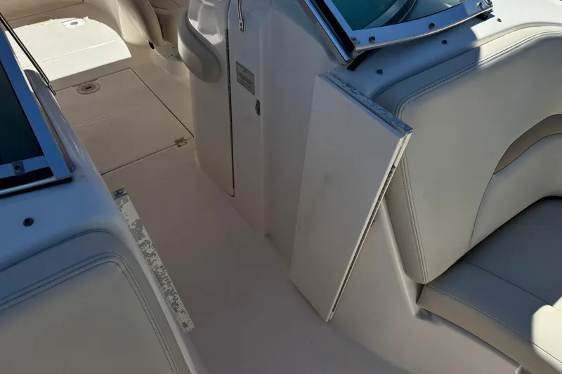 Slide: The Image of 2003 Chaparral Sunesta 263 boat interior with white seating and open storage compartment. - 17