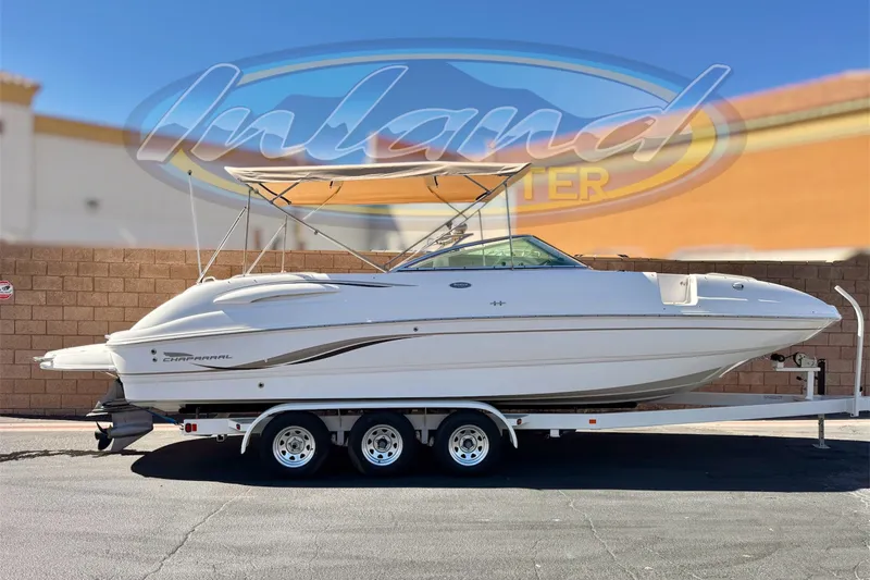 The Image of 2003 Chaparral Sunesta 263 boat on trailer, displayed outdoors under clear sky. - 0