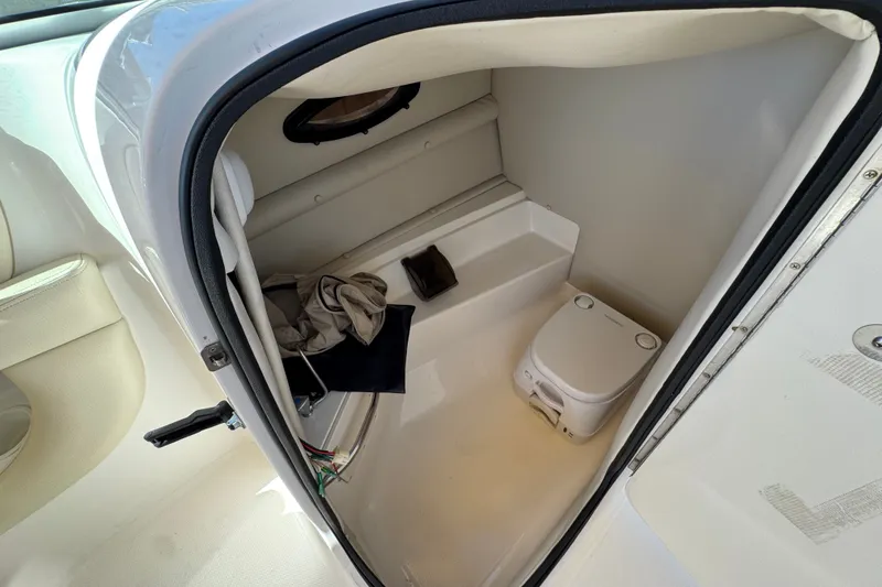 Slide: The Image of Interior of 2003 Chaparral Sunesta 263 boat with compact toilet and storage space. - 30